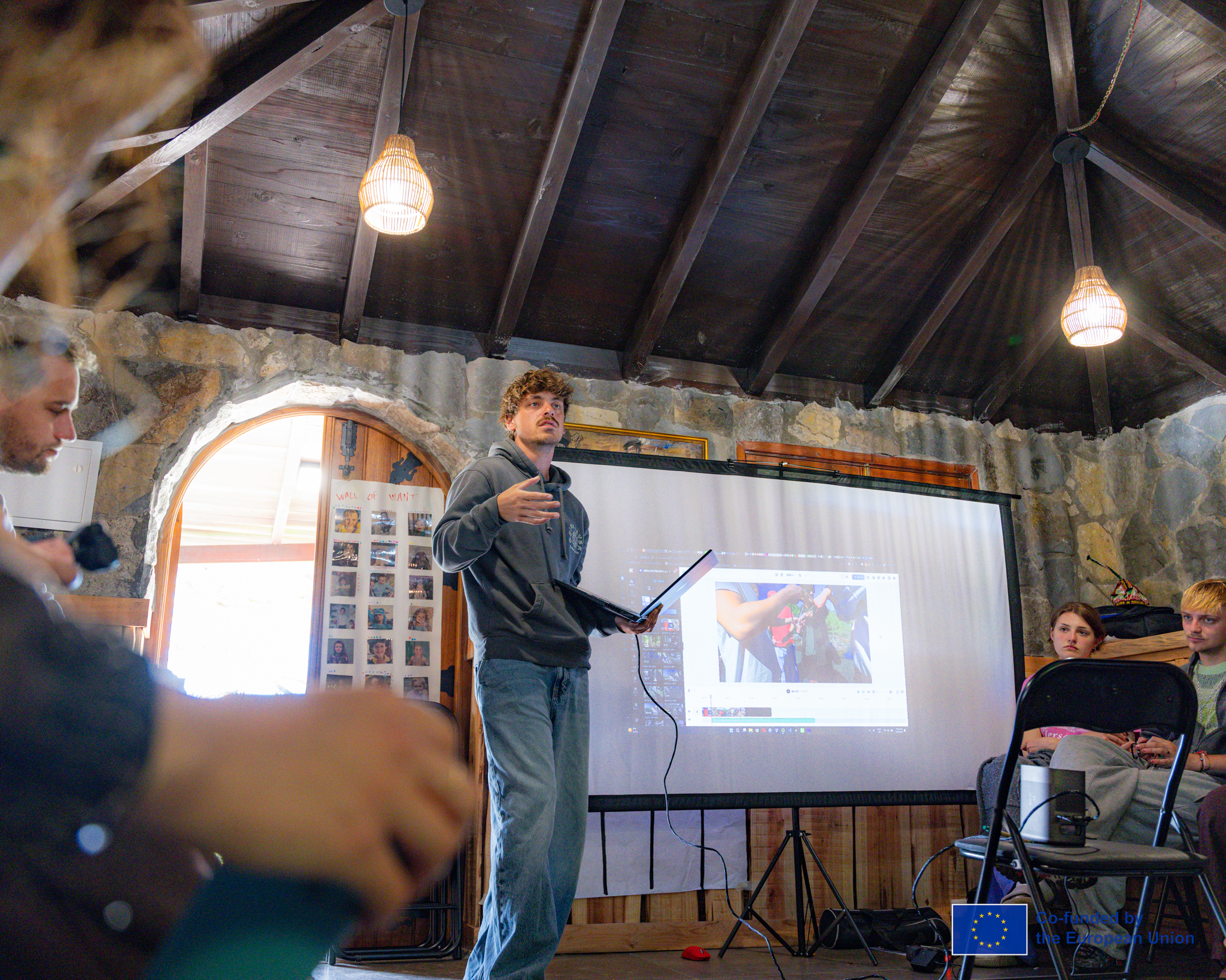 Young people presenting a project inside a traditional stone building.